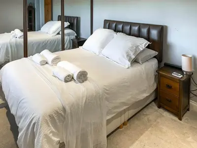 a bedroom with two beds with white sheets and towels at Number 8 in Camborne