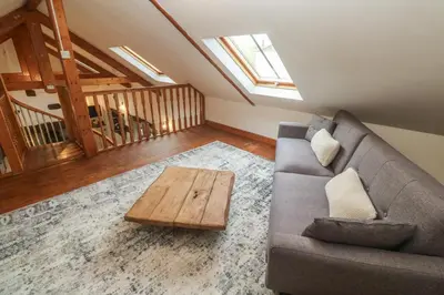 a living room with a couch and a coffee table at Riverside Barn in Truro