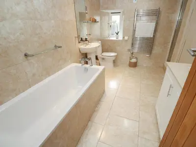 a bathroom with a tub and a toilet and a sink at Riverside Barn in Truro