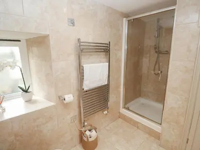a bathroom with a shower with a glass door at Riverside Barn in Truro