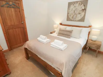 a bedroom with a bed with two towels on it at Riverside Barn in Truro