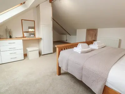 a bedroom with a bed with two towels on it at Riverside Barn in Truro