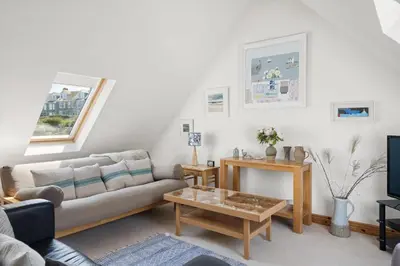 a living room with a couch and a coffee table at Spacious Home Overlooking Porthmeor Beach Parking in St Ives