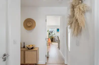 a hallway with a door leading to a living room at Boho-Chic Apartment with Sea Views & Parking in Newquay