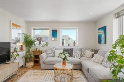 a living room with a couch and a table at Boho-Chic Apartment with Sea Views & Parking in Newquay