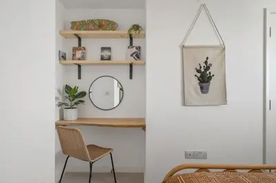 a room with a table and a mirror and a chair at Boho-Chic Apartment with Sea Views & Parking in Newquay