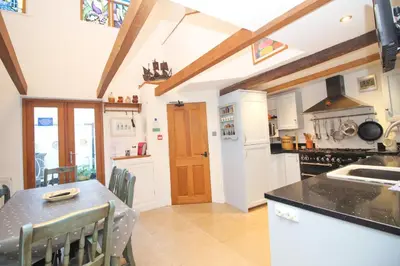 a kitchen with a table and a counter top at Unique town house with games room in Padstow