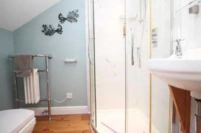 a bathroom with a shower and a sink at Unique town house with games room in Padstow