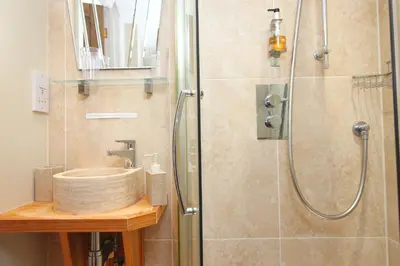 a bathroom with a sink and a shower at Unique town house with games room in Padstow