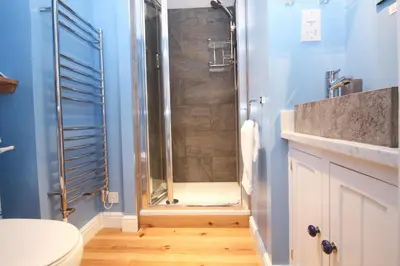 a bathroom with a shower with a toilet and a sink at Unique town house with games room in Padstow