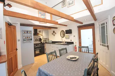 a kitchen and dining room with a table and chairs at Unique town house with games room in Padstow