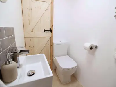 a bathroom with a toilet and a sink and a door at Holiday Home für 1 Personen - 1 Kind ca- 33 m² in Ludgvan- Cornwall by Interhome in Ludgvan