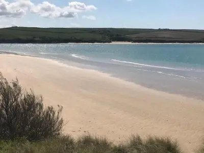 a sandy beach with the ocean in the background at Holiday Home Idyllisches Landhaus Rosemary by Interhome in Liskeard