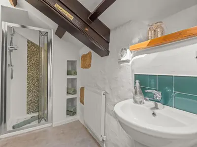 a bathroom with a sink and a shower at Holiday Home Idyllisches Landhaus mit wunderschönem Garten by Interhome in Liskeard