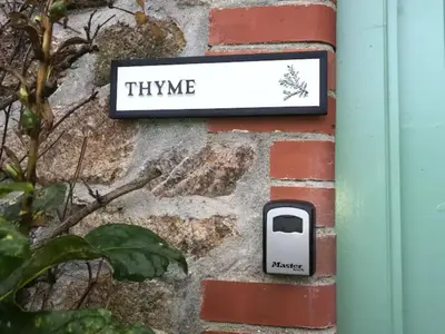 a sign that says thyme on a brick wall at Holiday Home Idyllisches Landhaus mit wunderschönem Garten by Interhome in Liskeard