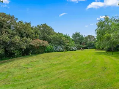a grassy field with picnic tables in a park at Holiday Home Idyllisches Landhaus mit wunderschönem Garten by Interhome in Liskeard