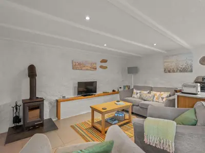 a living room with a couch and a wood stove at Holiday Home Idyllisches Landhaus mit wunderschönem Garten by Interhome in Liskeard