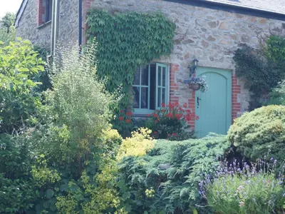 a brick house with a green door and a garden at Holiday Home Idyllisches-haustierfreundliches Landhaus Lavender by Interhome in Liskeard