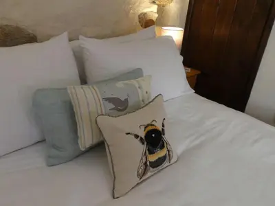 a bed with a bumble bee pillow on it at Holiday Home Idyllisches-haustierfreundliches Landhaus Lavender by Interhome in Liskeard