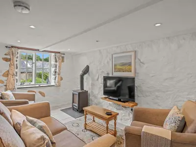 a living room with couches and a flat screen tv at Holiday Home Idyllisches-haustierfreundliches Landhaus Lavender by Interhome in Liskeard