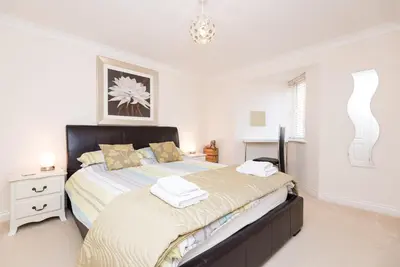 a bedroom with a bed with two towels on it at Russell Court 2 - Beautifully furnished modern apartment with parking and views over Looe river and town in Looe