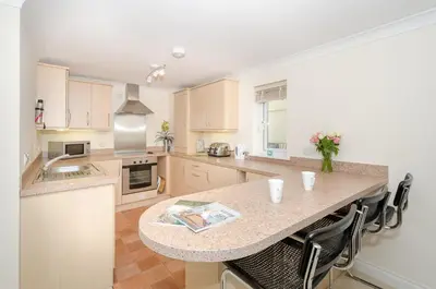 a kitchen with a large island in the middle at Russell Court 2 - Beautifully furnished modern apartment with parking and views over Looe river and town in Looe