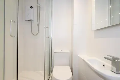a bathroom with a shower and a toilet and a sink at Russell Court 2 - Beautifully furnished modern apartment with parking and views over Looe river and town in Looe
