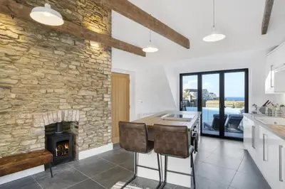 a kitchen with a stone wall and a fireplace at Stylish Apartment Sea Views Central Newquay in Newquay