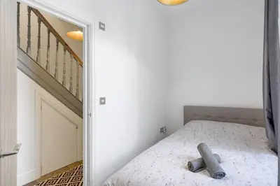 a bedroom with a bed with a mirror next to a staircase at Stylish Apartment Sea Views Central Newquay in Newquay