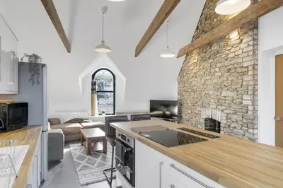 a kitchen and living room with a stone fireplace at Stylish Apartment Sea Views Central Newquay in Newquay