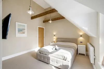 a bedroom with a white bed in a attic at Stylish Apartment Sea Views Central Newquay in Newquay