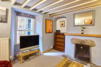 a living room with a television and a fireplace at Cornish Cottage St Agnes free parking and garden in St. Agnes