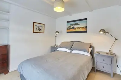 a bedroom with a bed with two lamps on it at Cornish Cottage St Agnes free parking and garden in St. Agnes