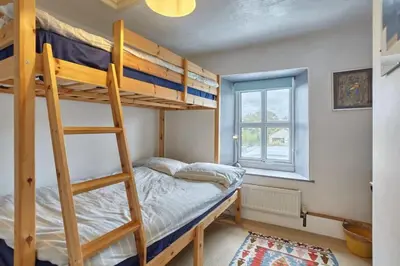 a bedroom with two bunk beds and a ladder at Cornish Cottage St Agnes free parking and garden in St. Agnes