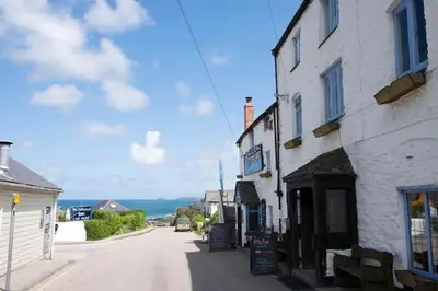 a building on the side of a street next to the ocean at Cornish Cottage St Agnes free parking and garden in St. Agnes
