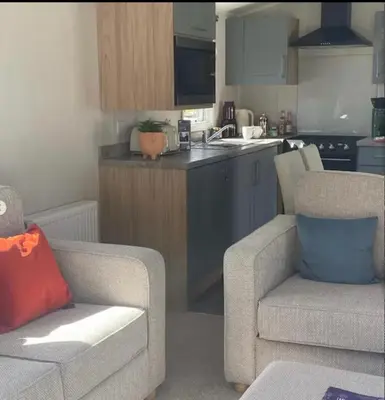 a kitchen with a couch and two chairs in a room at Cosy three bedroom holiday home in Parkdean Newquay in Newquay
