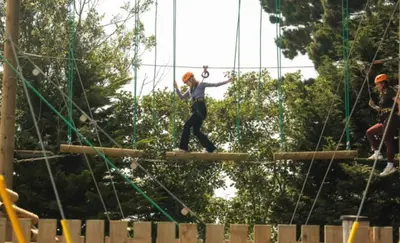 a woman on a ropes course at an amusement park at Cosy three bedroom holiday home in Parkdean Newquay in Newquay