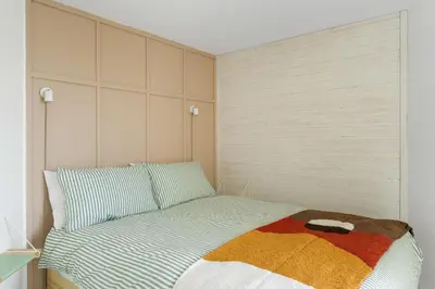 a small bedroom with a bed with a striped blanket at Beach Life Cabin Vibes Ocean Views nr Bude in Bude