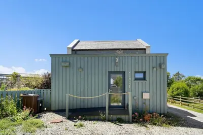 a green tiny house with a yellow rope at Beach Life Cabin Vibes Ocean Views nr Bude in Bude