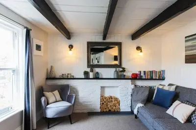 a living room with a couch and a fireplace at Listed Fisherman's Cottage Mevagissey Sea Views in Mevagissey