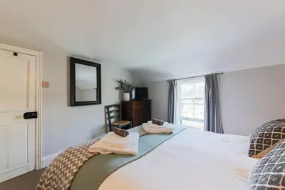 a bedroom with a large bed with towels on it at Listed Fisherman's Cottage Mevagissey Sea Views in Mevagissey