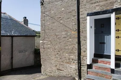 a brick building with a door on the side of it at Listed Fisherman's Cottage Mevagissey Sea Views in Mevagissey