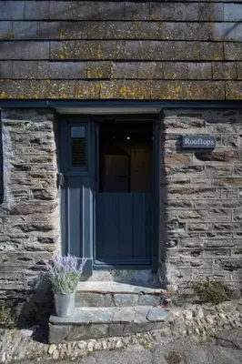 a brick building with a blue door and a potted plant at Listed Fisherman's Cottage Mevagissey Sea Views in Mevagissey