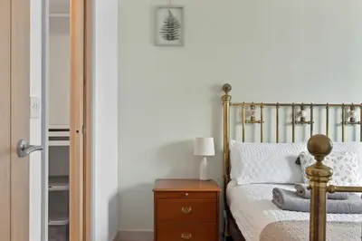 a bedroom with a bed and a table with a lamp at Scandi Style Apartment in Central Falmouth in Falmouth