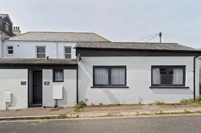 a white house on the side of a street at Scandi Style Apartment in Central Falmouth in Falmouth
