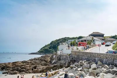 a group of people standing on a beach near the water at Scandi Style Apartment in Central Falmouth in Falmouth