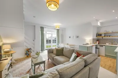 a living room with a couch and a kitchen at Cosy Cottage nr Bodmin Moor Private Parking in Helland