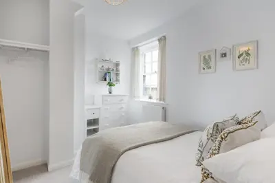 a white bedroom with a bed and a window at Cosy Cottage nr Bodmin Moor Private Parking in Helland