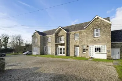 a brick house with a car parked in the driveway at Cosy Cottage nr Bodmin Moor Private Parking in Helland
