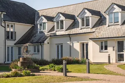 a row of houses with a statue in front of them at Stylish Apartment Garden with Beautiful Sea Views in Newquay